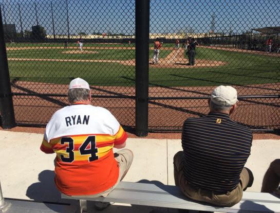 A fan wearing a Nolan Ryan jersey sits next to Nolan Ryan himself at Astros camp. (@brianmctaggart)