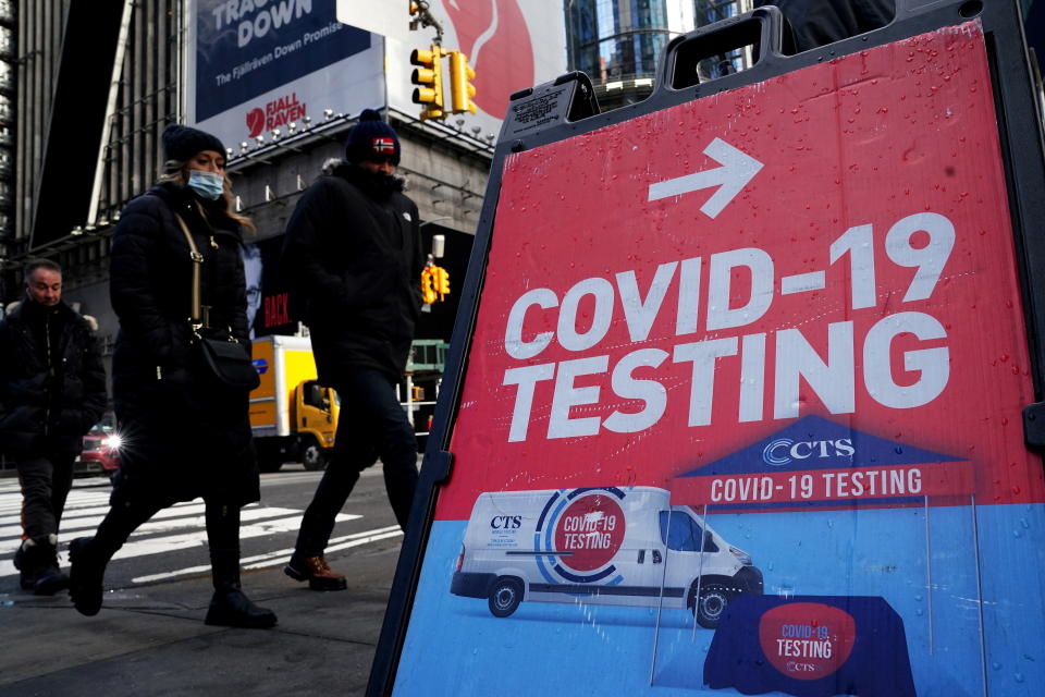 People walk past a COVID-19 testing sign during the coronavirus disease (COVID-19) pandemic in the Manhattan borough of New York City, New York, U.S., January 20, 2022.  REUTERS/Carlo Allegri