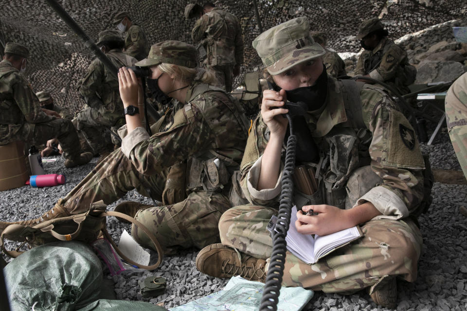 A cadet uses a field radio to call in live fire coordinates, Friday, Aug. 7, 2020, in West Point, N.Y. The pandemic is not stopping their summer training. Cadets had to wear masks this year for much of the training in a wooded area just beyond the main gates of the U.S. Military Academy. (AP Photo/Mark Lennihan)