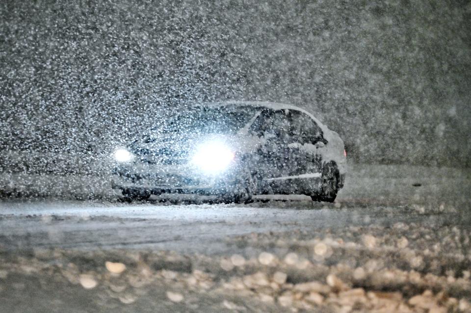A motorist travels along Waverly Road during a heavy snow storm on Friday, March 3, 2023, in Lansing.