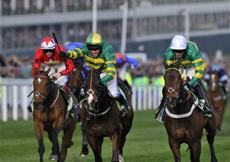 Jockey Barry Geraghty on Jezki (C) wins the Champion Hurdle Challenge Trophy ahead of jockey Tony McCoy on My Tent Or Yours (R) at the Cheltenham Festival horse racing meet in Gloucestershire, western England March 11, 2014. REUTERS/Toby Melville