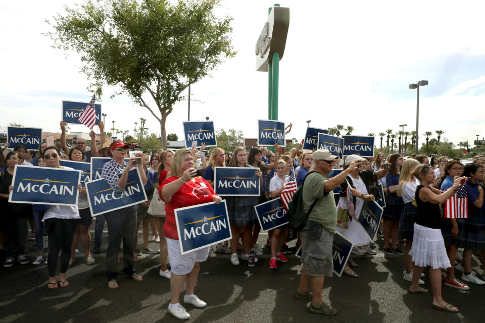 <p>People hold signs and watch as a hearse carrying the casket of Sen. John McCain is escorted by Arizona State Troopers to a memorial service at the North Phoenix Baptist Church on August 30, 2018 in Phoenix, Ariz. (Photo: Justin Sullivan/Getty Images) </p>