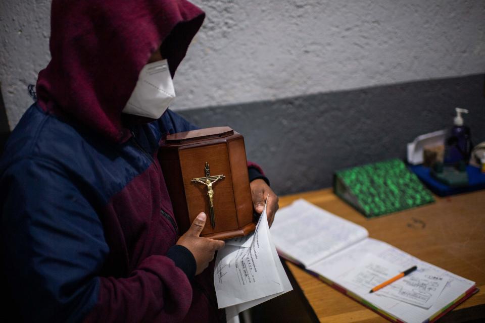 Este cliente recibe la urna con las cenizas de su padre después de haber sido incinerado. (Photo by PEDRO PARDO/AFP via Getty Images)