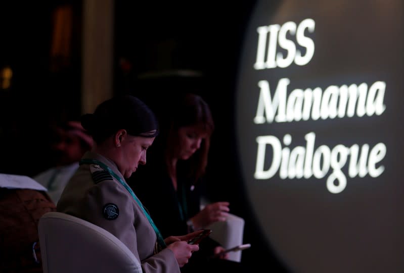 FILE PHOTO: German military officials check their mobile phones during the 15th Regional Security Summit IISS Manama Dialogue 2019, in Manama