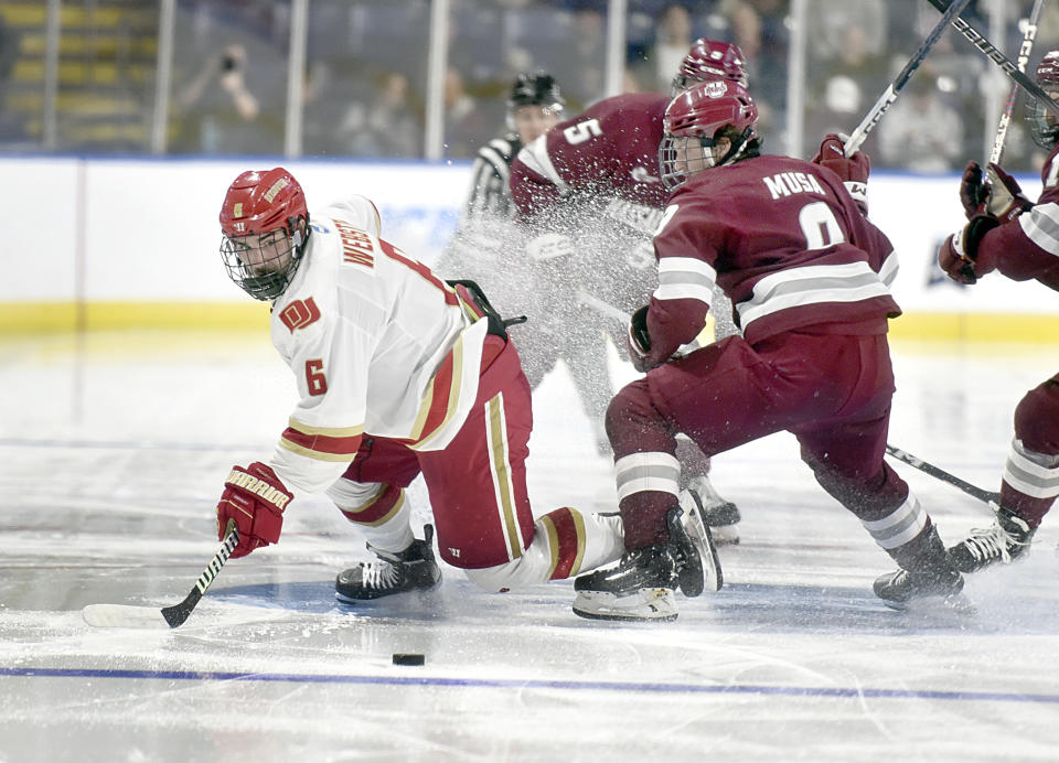 Denver's McKade Webster (6) and Massachusetts' Jack Musa (9) battle for the puck during the second period of a college hockey game in the NCAA Tournament, Thursday, March 28, 2024, Springfield, Mass. (Don Treeger/The Republican via AP)
