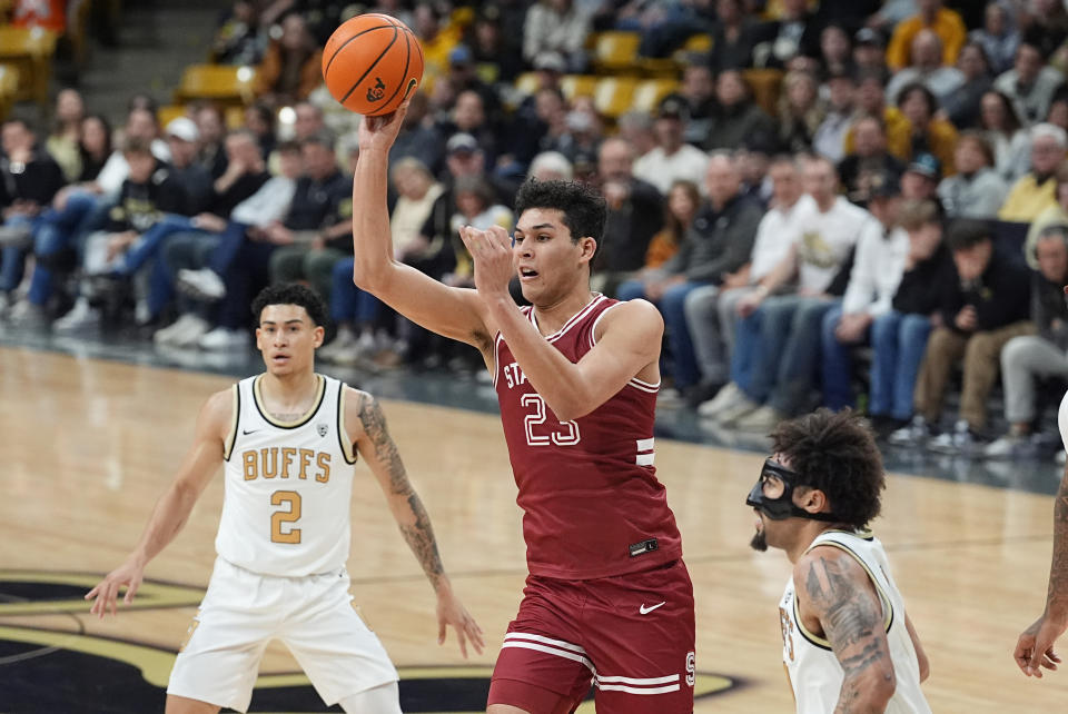 Stanford forward Brandon Angel, center, passes the ball as he drives between Colorado guards KJ Simpson, left, and J'Vonne Hadley in the first half of an NCAA college basketball game, Sunday, March 3, 2024, in Boulder, Colo. (AP Photo/David Zalubowski)