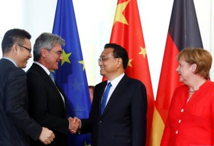 Chinese Prime Minister Li Keqiang shakes hands with Joe Kaeser, CEO of Siemens, as German Chancellor Angela Merkel looks on, during the signing ceremony of the treaties at the chancellery in Berlin, Germany, July 9, 2018. REUTERS/Fabrizio Bensch