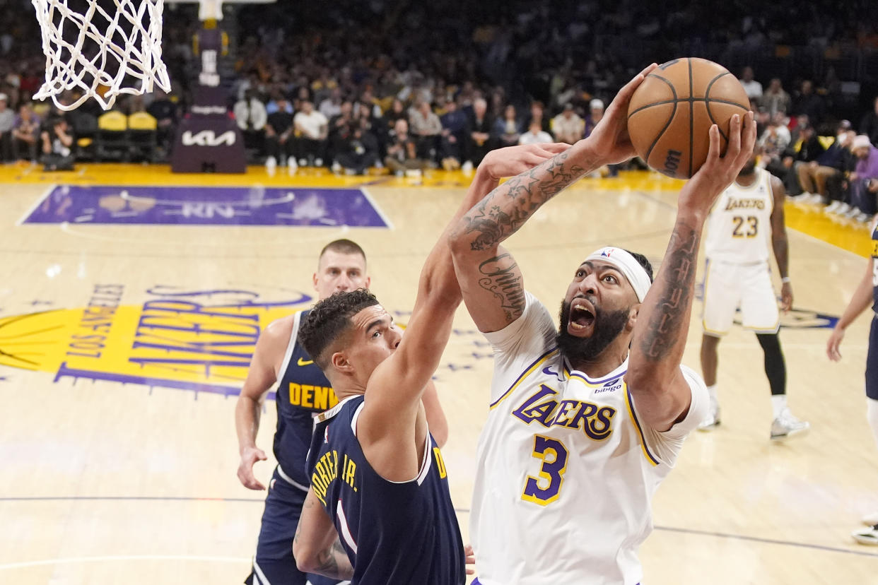 Los Angeles Lakers forward Anthony Davis, right, shoots as Denver Nuggets forward Michael Porter Jr. defends during the first half in Game 4 of an NBA basketball first-round playoff series Saturday, April 27, 2024, in Los Angeles. (AP Photo/Mark J. Terrill)