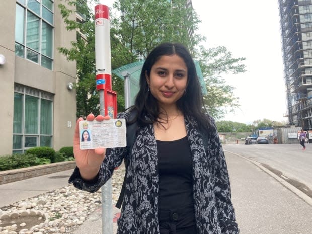 Vishwa Patne is seen here holding her foreign driver's licence near her home in Etobicoke on May 26, 2021. She's been unable to get her Ontario licence during the pandemic, forcing her to bike and use public transit despite knowing how to drive. (Katie Swyers/ CBC - image credit)