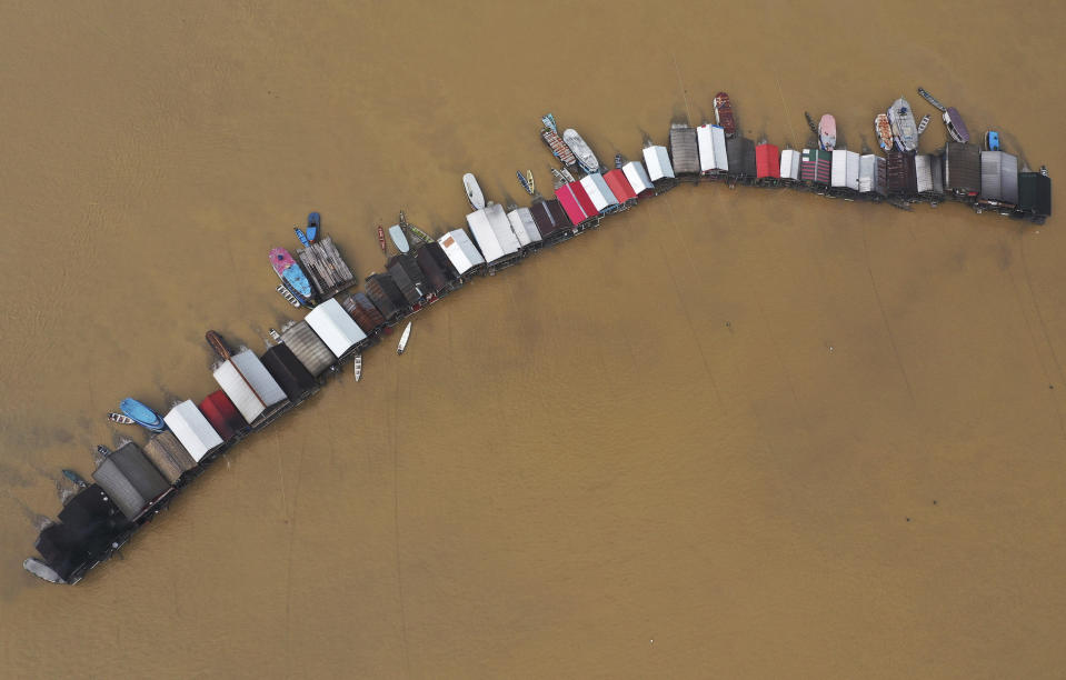 Dredging barges operated by illegal miners converge on the Madeira river, a tributary of the Amazon river, searching for gold, in Autazes, Amazonas state, Brazil, Thursday, Nov.25, 2021. Hundreds of mining barges have arrived during the past two weeks after rumors of gold spread, with environmentalists sounding the alarm about the unprecedented convergence of boats in the sensitive ecosystem. (AP Photo/Edmar Barros)