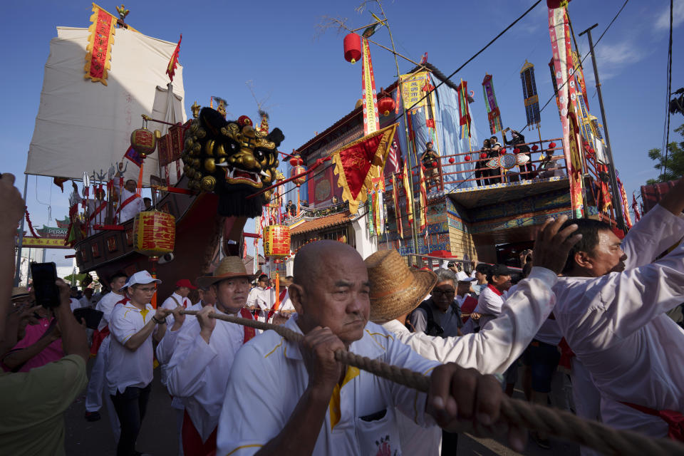 Ethnic Chinese devotees pull a special Wangkang ship through a nine-kilometer procession route in the historical city of Malacca with 22 stops where priests performed cleansing rituals to command evil spirits and other negative influences to board the boat during Wangkang or "royal ship" festival, Malaysia, Thursday, Jan. 11, 2024. The Wangkang festival was brought to Malacca by Hokkien traders from China and first took place in 1854. Processions have been held in 1919, 1933, 2001, 2012 and 2021. (AP Photo/Vincent Thian)