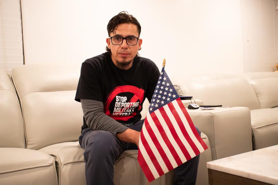 United States Navy veteran Alex Murillo with the flag he was given by a fellow soldier when he re-entered the U.S. after being deported, in Phoenix on Nov. 8, 2023.