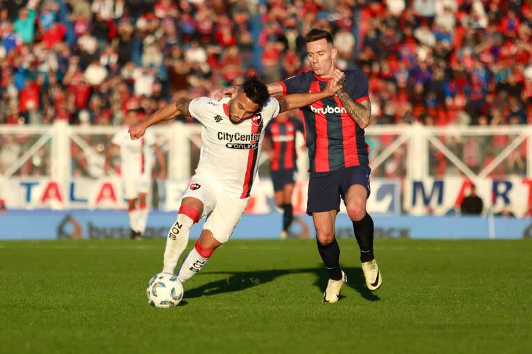 Malcom Braida intenta frenar un avance de Newell's; San Lorenzo rescató un empate con sabor a poco en el Nuevo Gasómetro