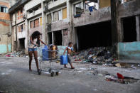 <p>Young residents haul water collected from hoses back to their family’s home in the Mangueira favela, May 4, 2017, in Rio de Janeiro. (Photo: Mario Tama/Getty Images) </p>