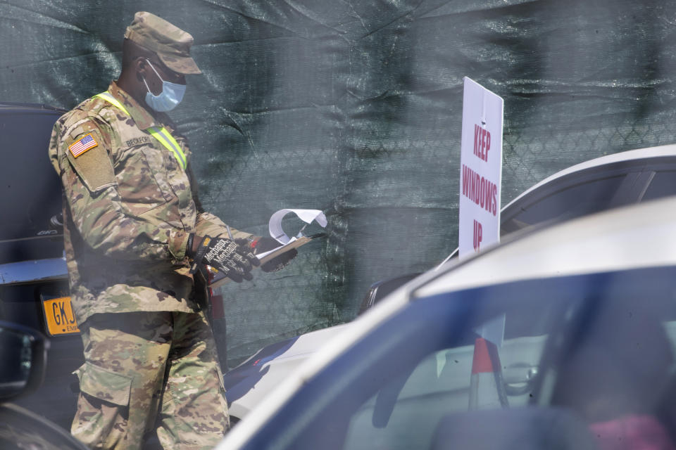 A member of the national guard checks people in at a drive thru COVID-19 testing sight Saturday, April 11, 2020, in the Flatbush neighborhood of the Brooklyn borough of New York. The new coronavirus causes mild or moderate symptoms for most people, but for some, especially older adults and people with existing health problems, it can cause more severe illness or death. (AP Photo/Mary Altaffer)