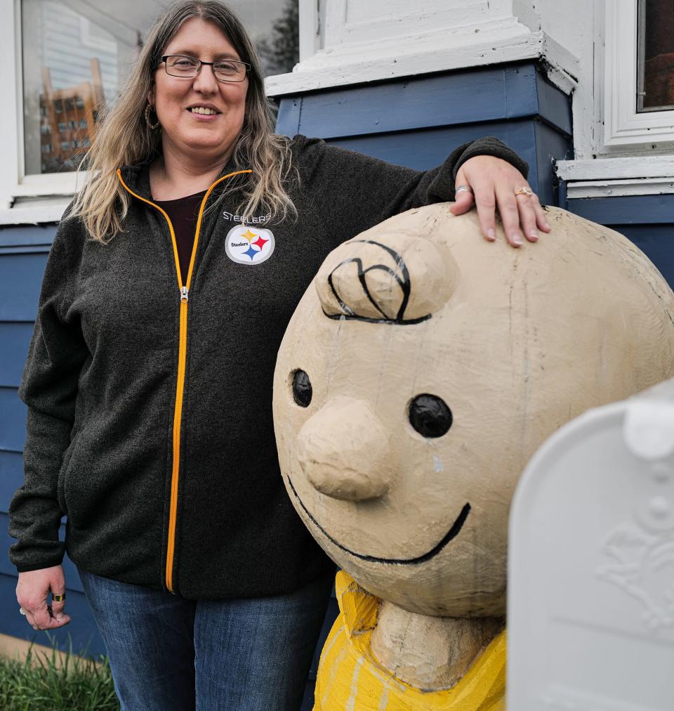 Jennifer Kalacanic from Lansing, is selling her heavy, wooden sculpture of Charlie Brown to free up some money for bills. Thursday, April 20, 2023.