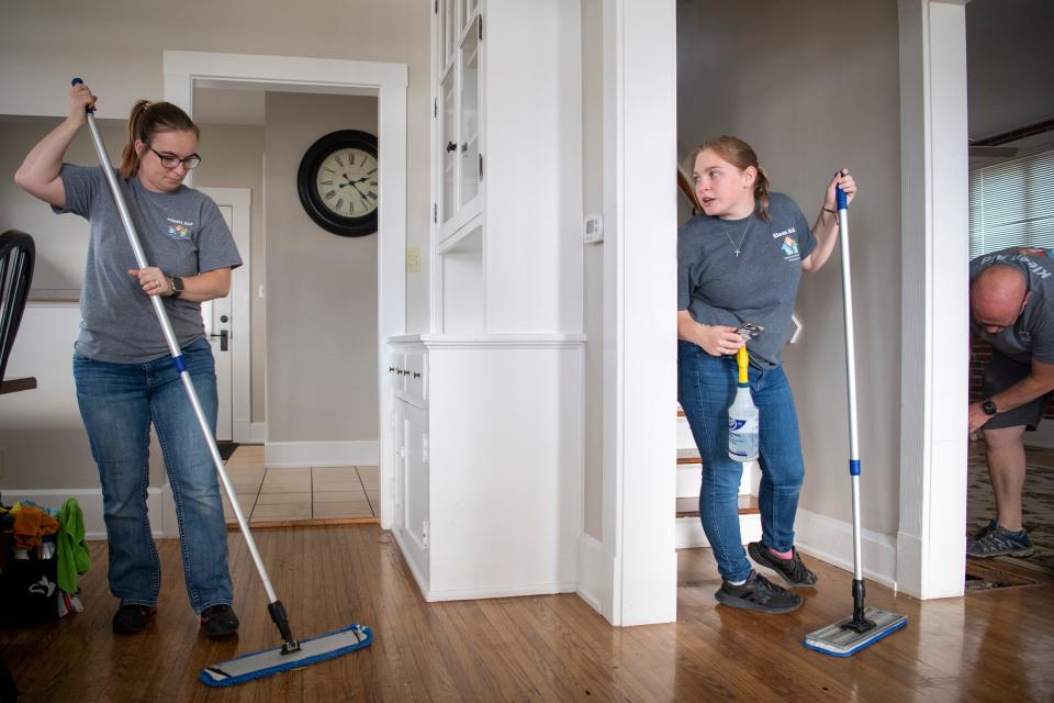 Cydney Marx, center, asks her mother Crystal Marx a question while they clean a Lockmaster Cottage in Downtown Newburgh, Ind., Tuesday, Oct. 24, 2023. The Marx’s own Kleen Aid Cleaning Services.