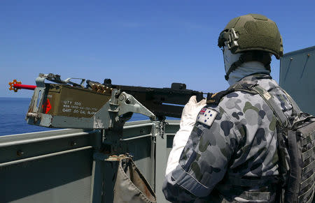 A crew member aboard the Royal Australian Navy frigate HMAS Newcastle holds a gun during Australia's largest maritime exercise 'Exercise Kakadu' being conducted off the coast of Darwin in northern Australia, September 8, 2018. Picture taken September 8, 2018. REUTERS/Jill Gralow