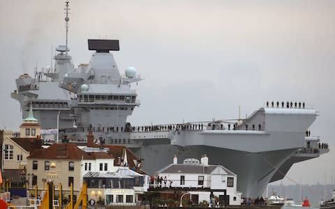 HMS Queen Elizabeth squeezes into Portsmouth Harbour, where - at its narrowest point - there was less than 66ft clearance on each side - Credit: Steve Parsons/PA