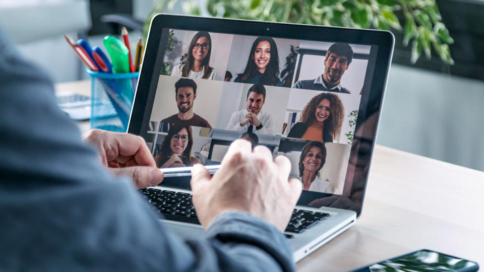 Back view of male employee speaking on video call with diverse colleagues on online briefing with laptop at home. (Getty Images)