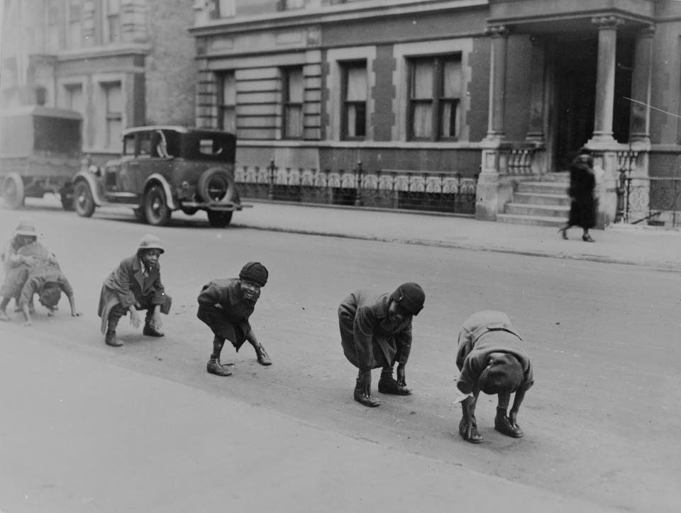 Circa 1935 Children playing a game of leap-frog in a street in Harlem, New York.   (Photo by Henry Guttmann/Getty Images)