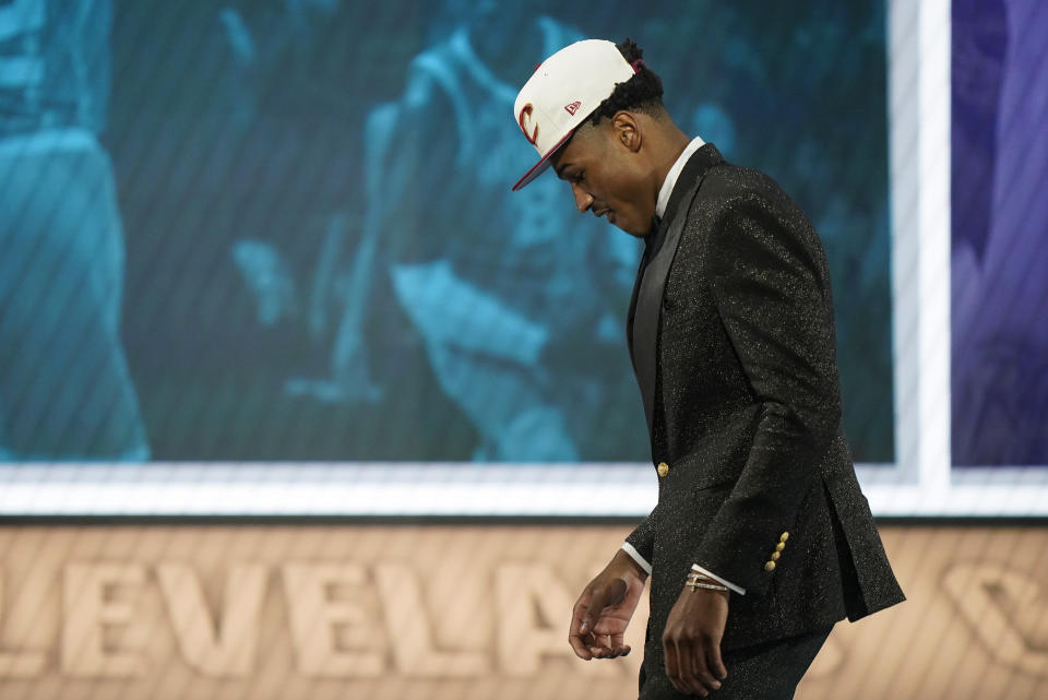 Ochai Agbaji walks across the stage after being selected 14th overall by the Cleveland Cavaliers in the NBA basketball draft, Thursday, June 23, 2022, in New York. (AP Photo/John Minchillo)