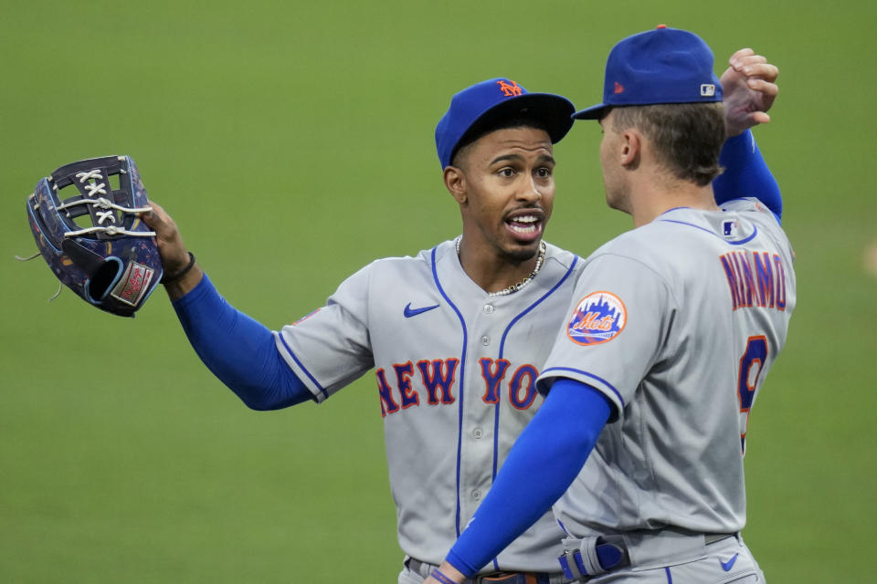 New York Mets shortstop Francisco Lindor, left, talks with center fielder Brandon Nimmo during the fourth inning of a baseball game against the San Diego Padres, Friday, July 7, 2023, in San Diego. (AP Photo/Gregory Bull)