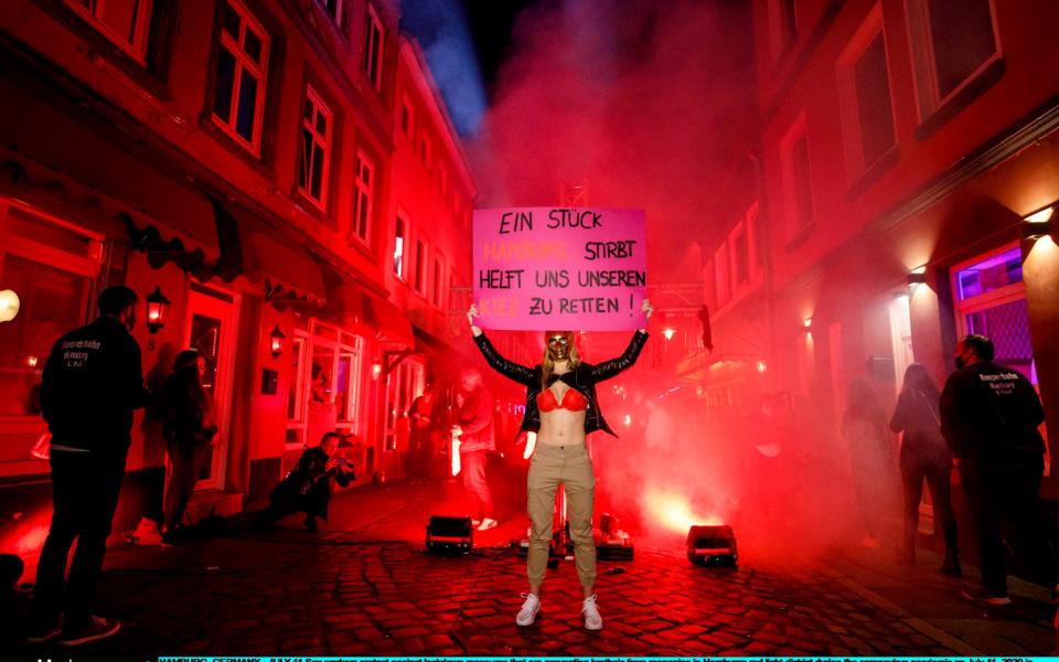 HAMBURG, GERMANY - JULY 11: Sex workers protest against lockdown measures that are preventing brothels from reopening in Hamburg's red light district during the coronavirus pandemic on July 11, 2020 in Hamburg, Germany. Sex workers across Germany are demanding an easing of ongoing lockdown measures that are preventing them from resuming their work. While authorities have lifted lockdown measures for most businesses in Germany, some, especially for those that involve close physical contact, remain in place. Legal sex workers say they are being treated unfairly, claiming they have developed adequate hygienic measures to prevent the spread of the virus and point out that other businesses that require similar physical proximity, such as hair salons and tattoo parlours, have been allowed to reopen. (Photo by Morris MacMatzen/Getty Images) - Morris MacMatzen/Getty Images Europe