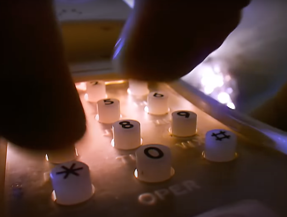 A close-up of a person's finger pressing a button on a telephone keypad