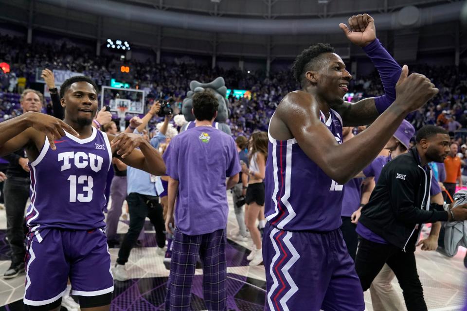TCU's Shahada Wells (13) and Damion Baugh, center, celebrate with fans who rushed the court after TCU defeated Texas in an NCAA college basketball game Wednesday, March 1, 2023, in Fort Worth, Texas. (AP Photo/Tony Gutierrez)