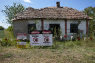 A sign saying "Access forbidden to unauthorized persons" is displayed in front of a house bought by Rio Tinto company in the village of Gornje Nedeljice, in the fertile Jadar Valley in western Serbia, Tuesday, Aug. 6, 2024. (AP Photo/Darko Vojinovic)