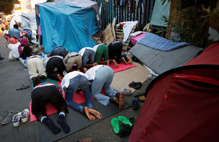 Migrants pray at a makeshift camp in Via Cupa (Gloomy Street) in downtown Rome, Italy, August 1, 2016. REUTERS/Max Rossi