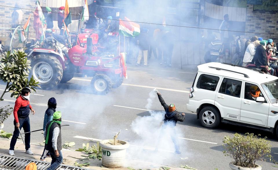 NEW DELHI, INDIA - JANUARY 26: A tear gas cannister being thrown back by protesting farmers after they entered the city on Republic Day at ITO on January 26, 2021 in New Delhi, India. Major scenes of chaos and mayhem at Delhi borders as groups of farmers allegedly broke barricades and police check posts and entered the national capital before permitted timings. Police used tear gas at Delhi's Mukarba Chowk to bring the groups under control. Clashes were also reported at ITO, Akshardham. Several rounds of talks between the government and protesting farmers have failed to resolve the impasse over the three farm laws. The kisan bodies, which have been protesting in the national capital for almost two months, demanding the repeal of three contentious farm laws have remained firm on their decision to hold a tractor rally on the occasion of Republic Day.(Photo by Arvind Yadav/Hindustan Times via Getty Images)