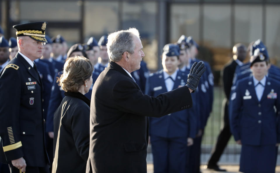 Former President George W. Bush and former first lady Laura Bush wave as they follow the casket of his father, former President George H.W. Bush Monday, Dec. 3, 2018, at Andrews Air Force Base, Md. (AP Photo/Alex Brandon, Pool)