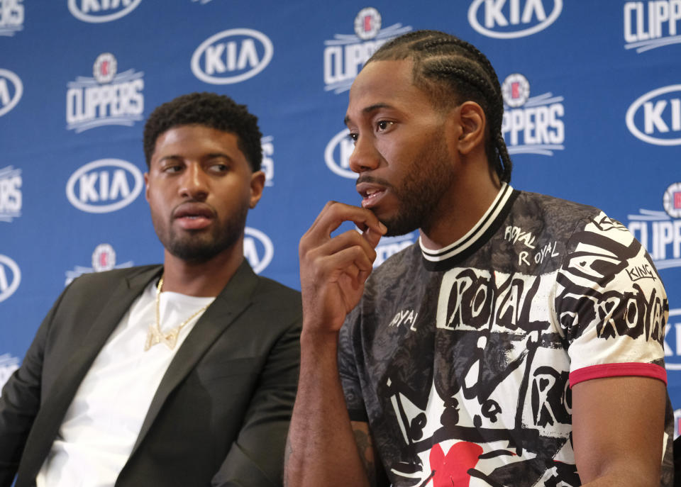 Paul George, left, and Kawhi Leonard attend a press conference in Los Angeles, Wednesday, July 24, 2019. Nearly three weeks after the native Southern California superstars shook up the NBA by teaming up with the Los Angeles Clippers, the dynamic duo makes its first public appearance. (AP Photo/Ringo H.W. Chiu)
