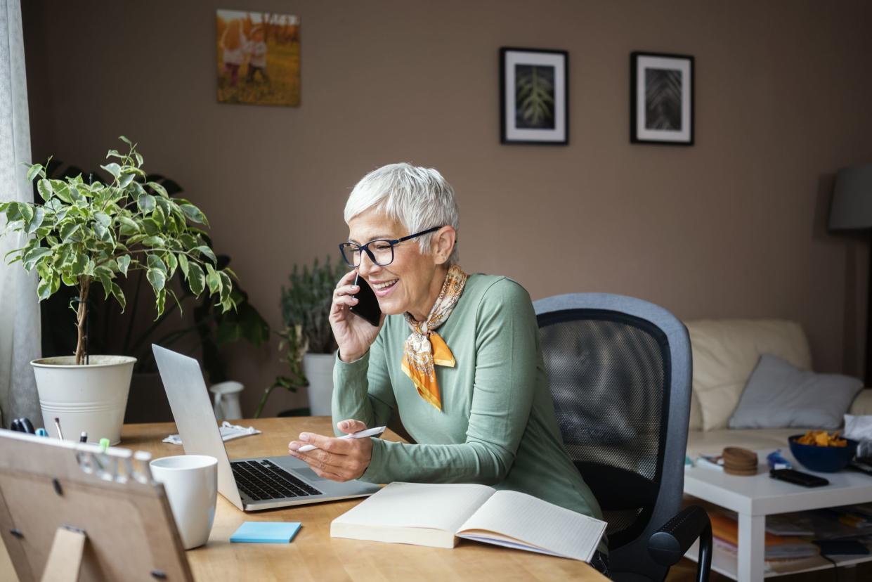 Mature woman working indoors at home office during quarantine caused by coronavirus Covid- 19