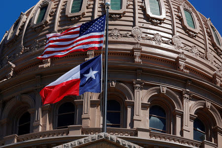 FILE PHOTO - The U.S flag and the Texas State flag fly over the Texas State Capitol in Austin, Texas, U.S. on March 14, 2017. REUTERS/Brian Snyder/File Photo