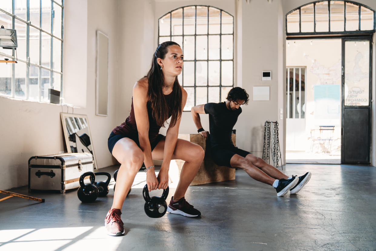 Cross training circuit in an health club inside an industrial loft with big windows.