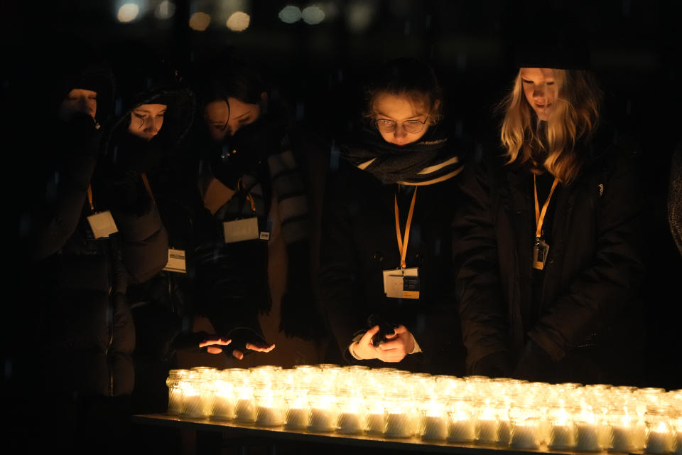 People light candles by the monument at the Birkenau Nazi death camp in Oswiecim, Poland, Saturday, Jan. 27, 2024. Survivors of Nazi death camps marked the 79th anniversary of the liberation of the Auschwitz-Birkenau camp during World War II in a ceremony in southern Poland.(AP Photo/Czarek Sokolowski)