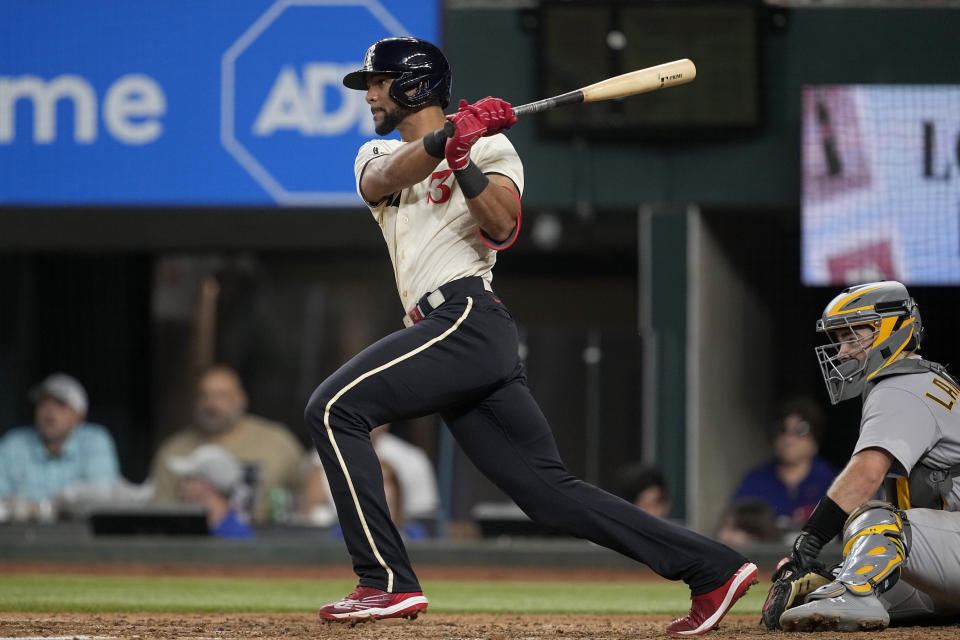 Texas Rangers' Leody Taveras follows through on a run-scoring single as Oakland Athletics catcher Shea Langeliers looks on in the sixth inning of a baseball game, Saturday, Sept. 9, 2023, in Arlington, Texas. Mitch Garver scored on the hit. (AP Photo/Tony Gutierrez)