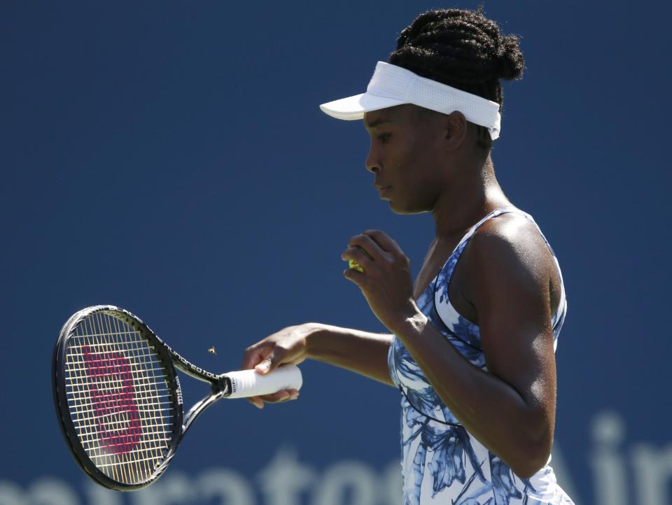 Venus Williams of the U.S. reacts an insect while preparing to serve to Kimiko Date-Krumm of Japan during their match at the 2014 U.S. Open tennis tournament in New York