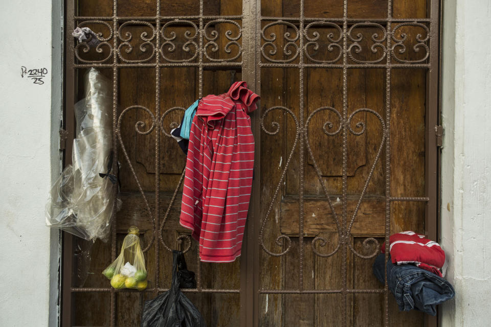 Clothes belonging to migrants hang in a door next to the Mexican Commission for Migrant Assistance office where migrants wait to get the documents needed that allows them to stay in Mexico, in Tapachula, Thursday, June 20, 2019. The flow of migrants into southern Mexico has seemed to slow in recent days as more soldiers, marines, federal police, many as part of Mexico's newly formed National Guard, deploy to the border under a tougher new policy adopted at a time of increased pressure from the Trump administration. (AP Photo/Oliver de Ros)