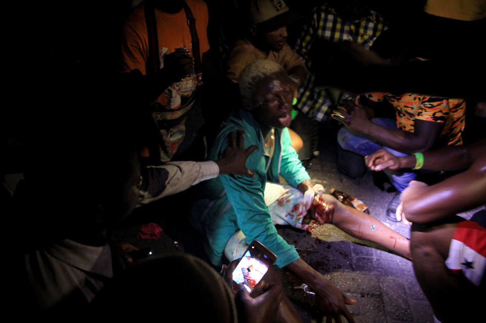 People come to the aid of a man who was wounded when security forces officers opened fire on a protest against brutality at the Lekki toll gate on Oct. 20, 2020.<span class="copyright">Adetona Omokanye—Getty Images</span>