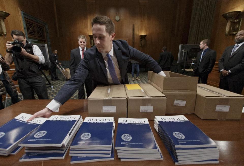 Copies of President Barack Obama’s proposed budget for fiscal 2015 are set out for distribution by Senate Budget Committee Clerk Adam Kamp, on Capitol Hill in Washington, Tuesday, March 4, 2014. Obama's fiscal blueprint, which he is sending Congress today, was expected to include proposals to upgrade aging highways and railroads, finance more pre-kindergarten programs and enhance job training. (AP Photo/J. Scott Applewhite)