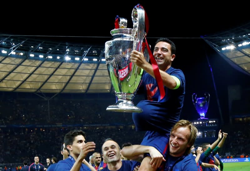 FOTO DE ARCHIVO: El barcelonés Xavi celebra con el trofeo y sus compañeros después de ganar la UEFA Champions League