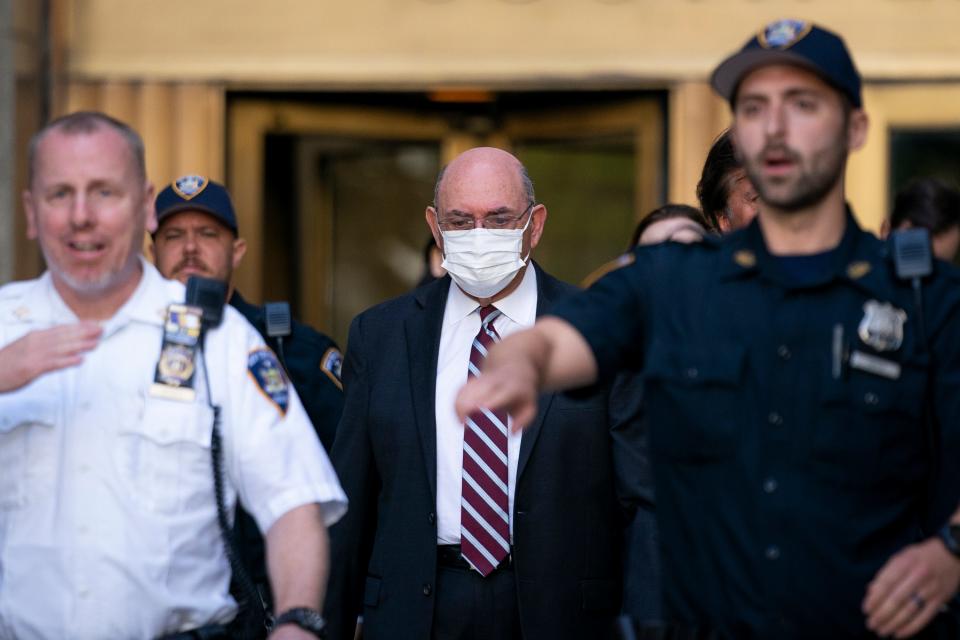 Law enforcement personnel escort the Trump Organization's former Chief Financial Officer Allen Weisselberg, center, as he departs court on Aug. 12, 2022, in New York.