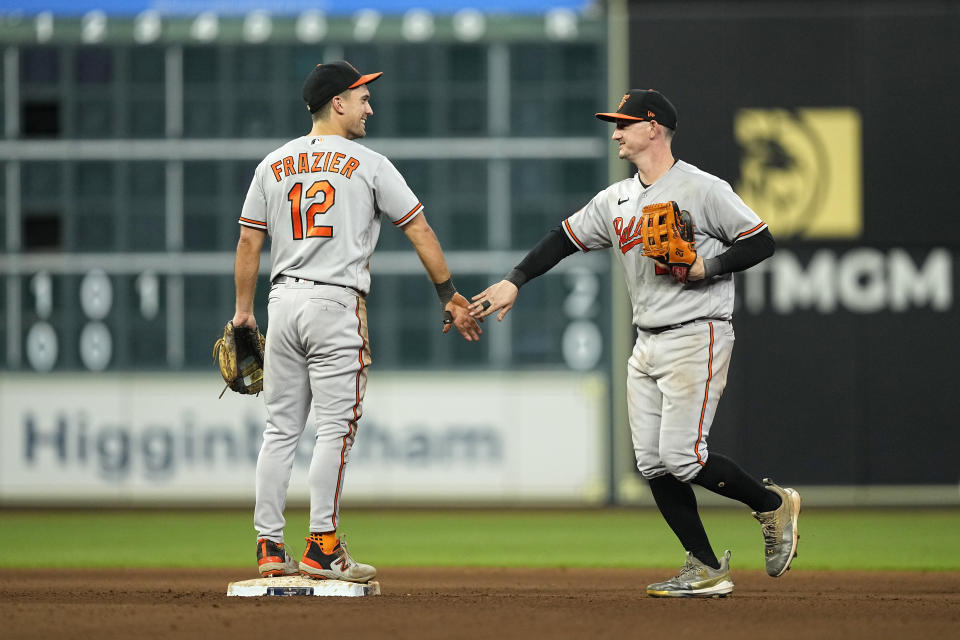 Baltimore Orioles' Adam Frazier (12) and Austin Hays celebrate after a baseball game against the Houston Astros Tuesday, Sept. 19, 2023, in Houston. The Orioles won 9-5. (AP Photo/David J. Phillip)