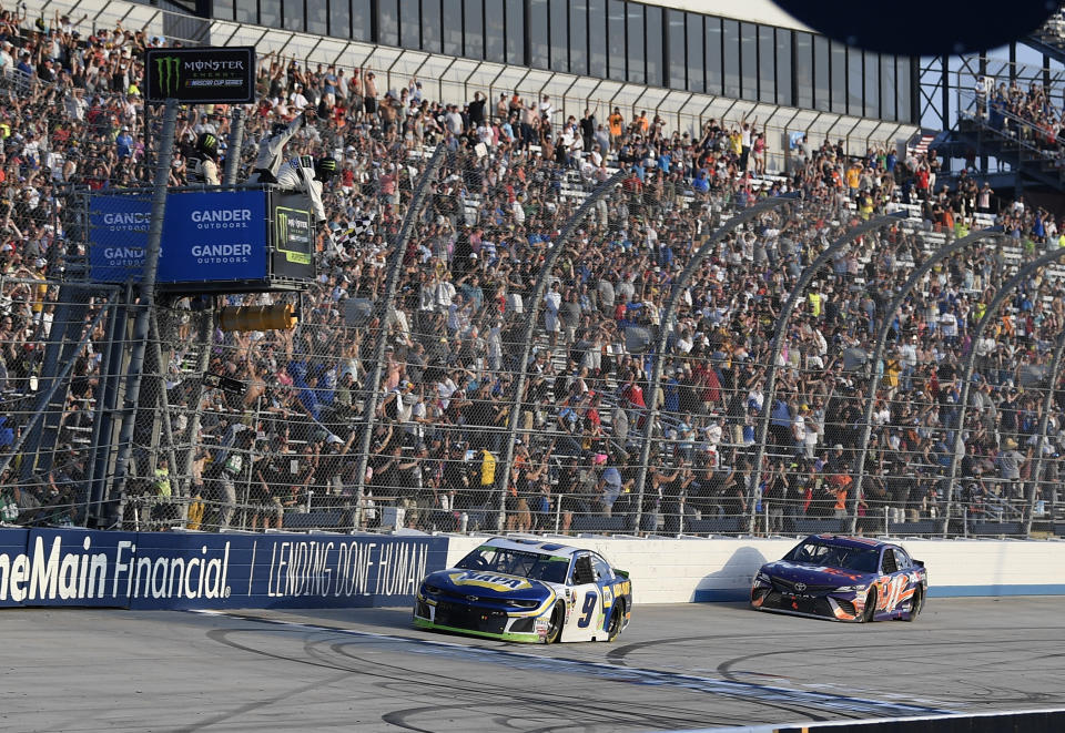 Chase Elliott (9) takes the checkered flag in front of Denny Hamlin (11) to win a NASCAR Cup Series auto race, Sunday, Oct. 7, 2018, at Dover International Speedway in Dover, Del. (AP Photo/Nick Wass)