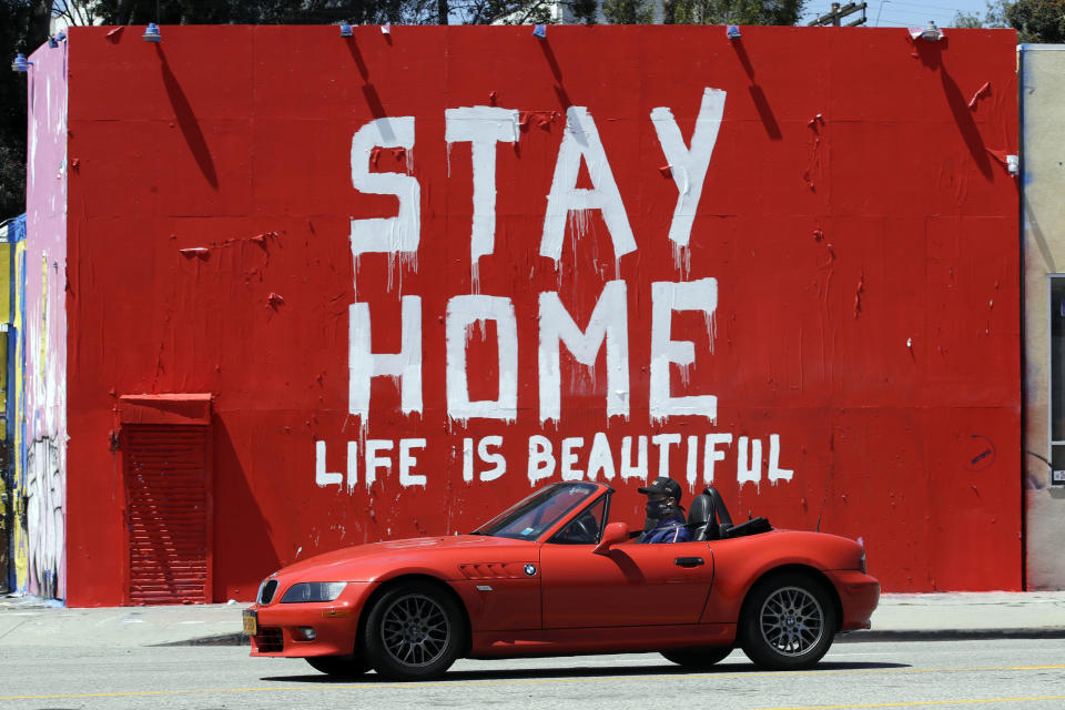 FILE - In this Tuesday, April 14, 2020 file photo, a mural reads "Stay Home, Life is Beautiful' in Los Angeles. Murals with themes centered around the Coronavirus have been popping up on the walls of businesses in the California city. (AP Photo/Marcio Jose Sanchez)