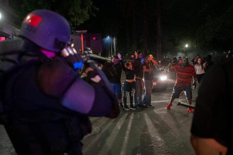 A Sacramento Police officer aims at demonstrators at L and 10th streets during a protest over the death of George Floyd on May 31, 2020, in Sacramento.